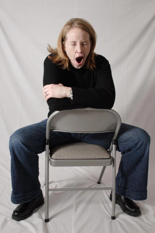 a woman sitting on a chair with her mouth open