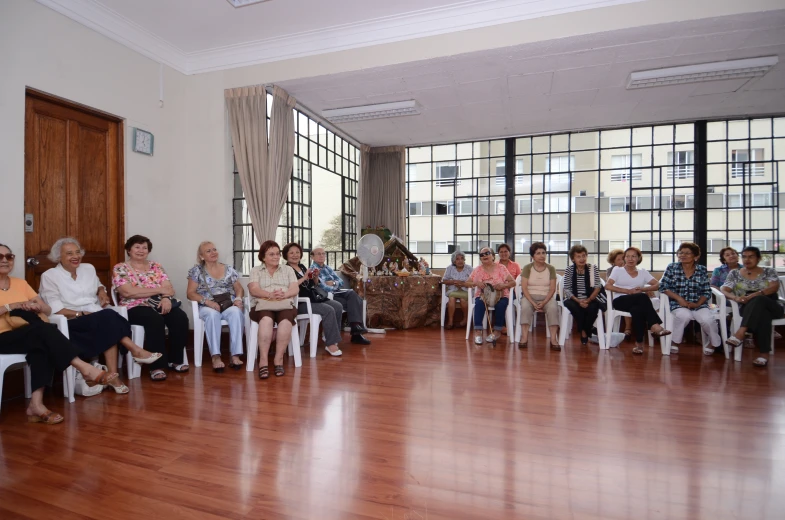 many people are in chairs listening to a speaker