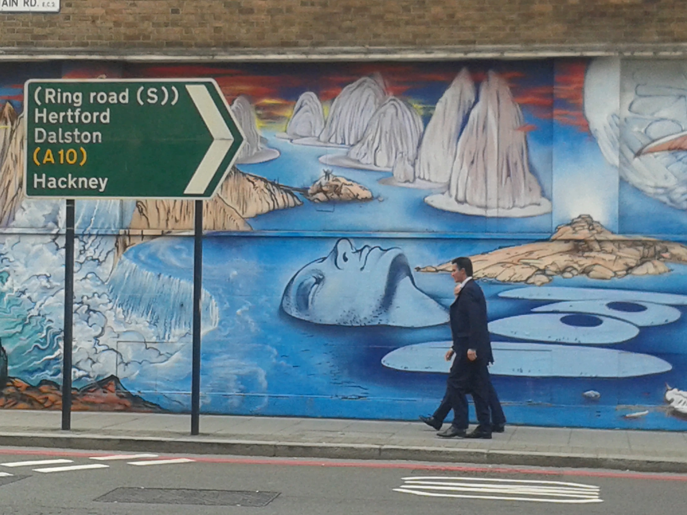 a man walking past a painted mural
