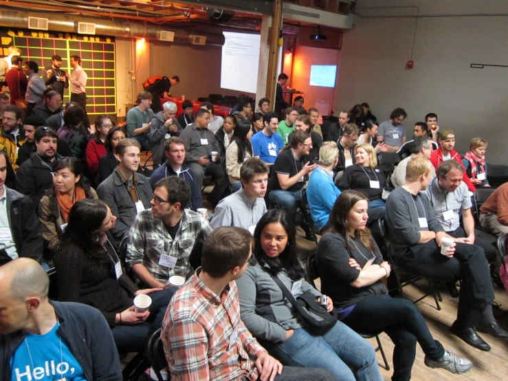 a crowd of people are listening to someone in a conference