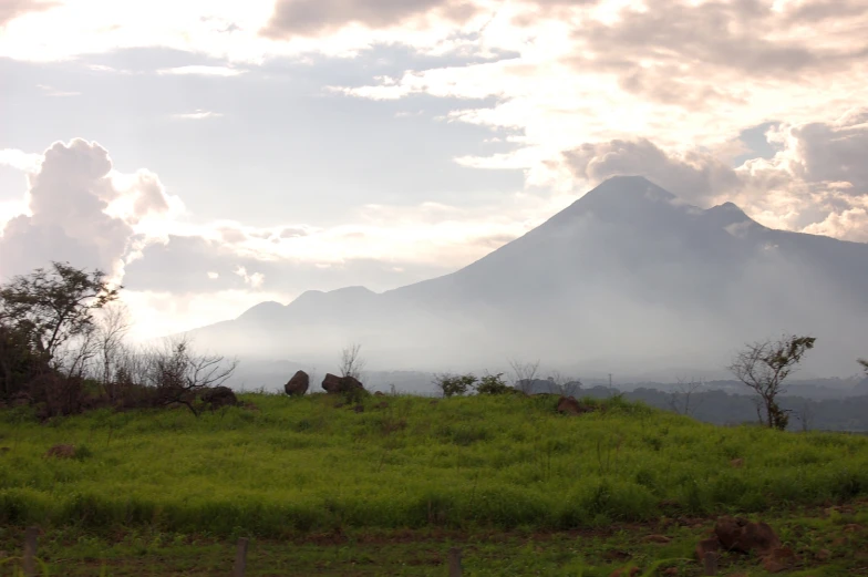 a mountain range in the distance under a partly cloudy sky