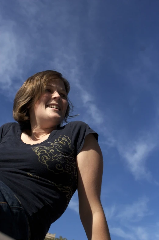 a woman smiling and flying a kite in the sky