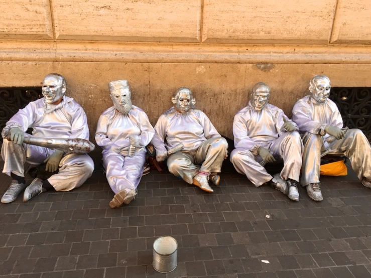 five different color statues sitting in front of a building