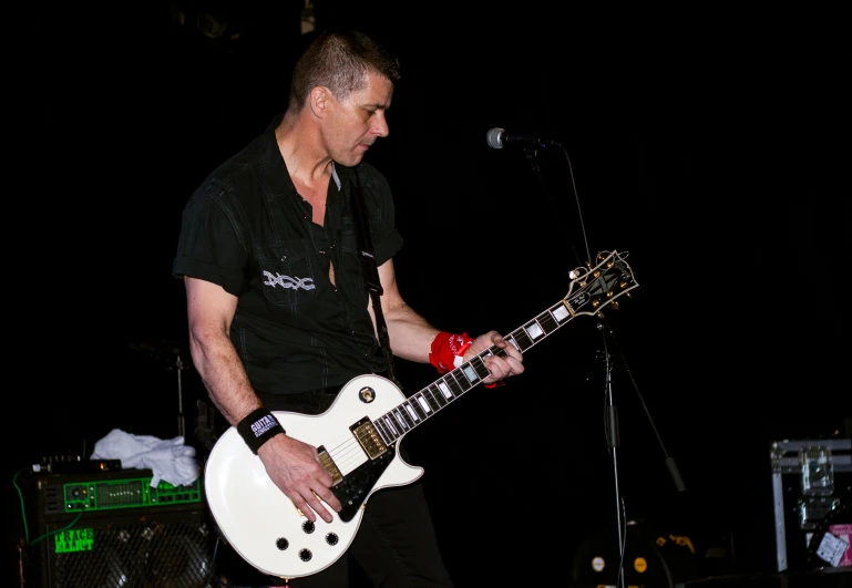 a man holding a white guitar while playing