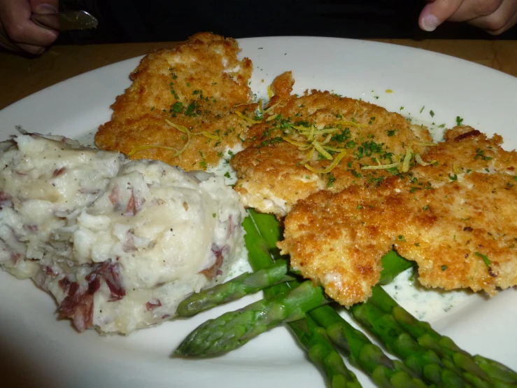 a plate with green asparagus and some food