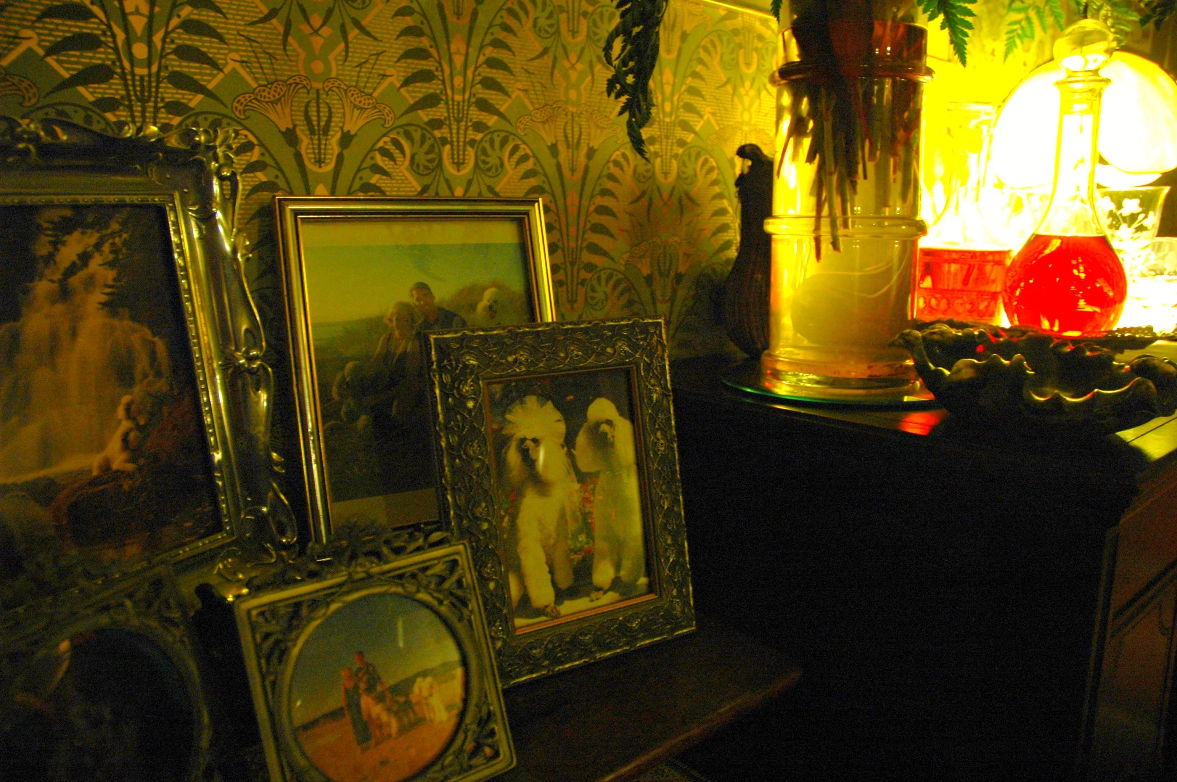 a collection of paintings is displayed on a mantle