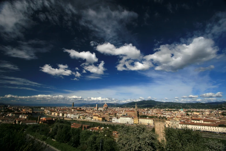 a city is under a blue sky with puffy clouds