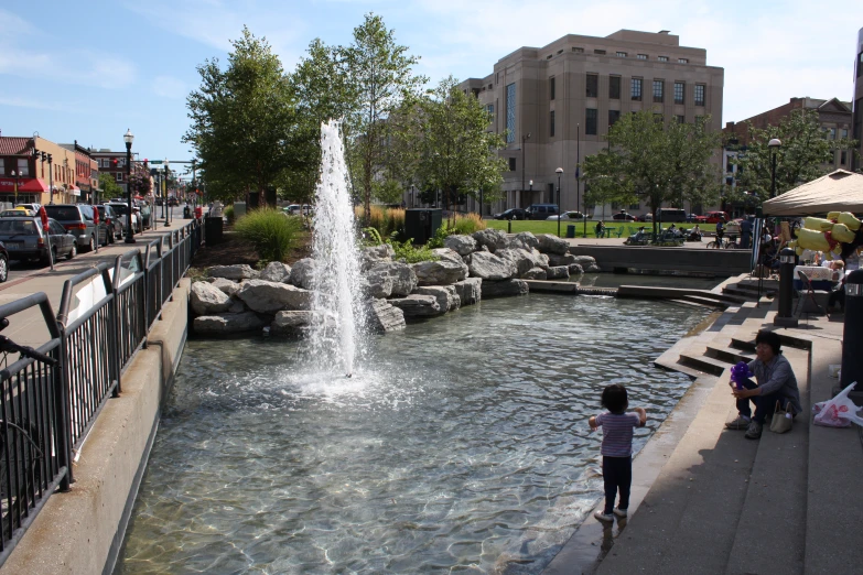 people standing in front of a fountain on the river