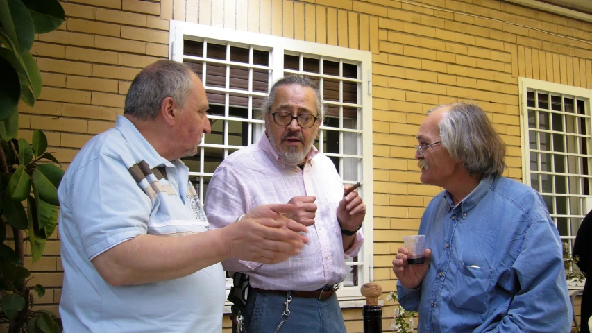 three men with glasses are standing outside