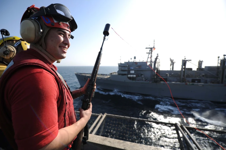 the man is holding a gun while on a boat