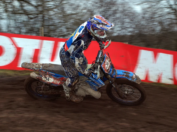 a dirt bike rider doing a trick in the mud