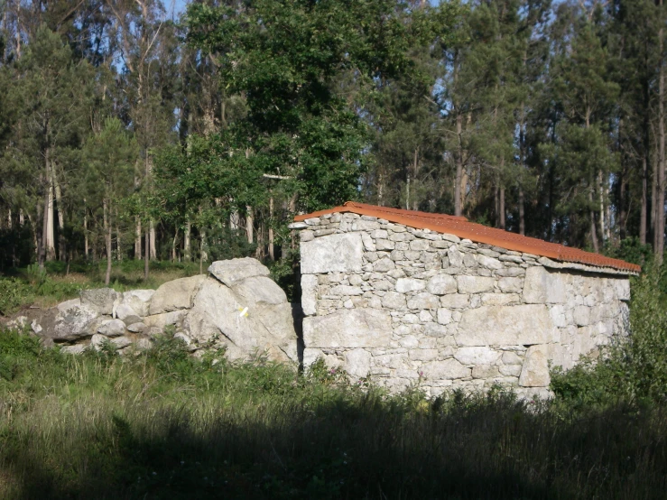 an old brick building sitting next to a forest