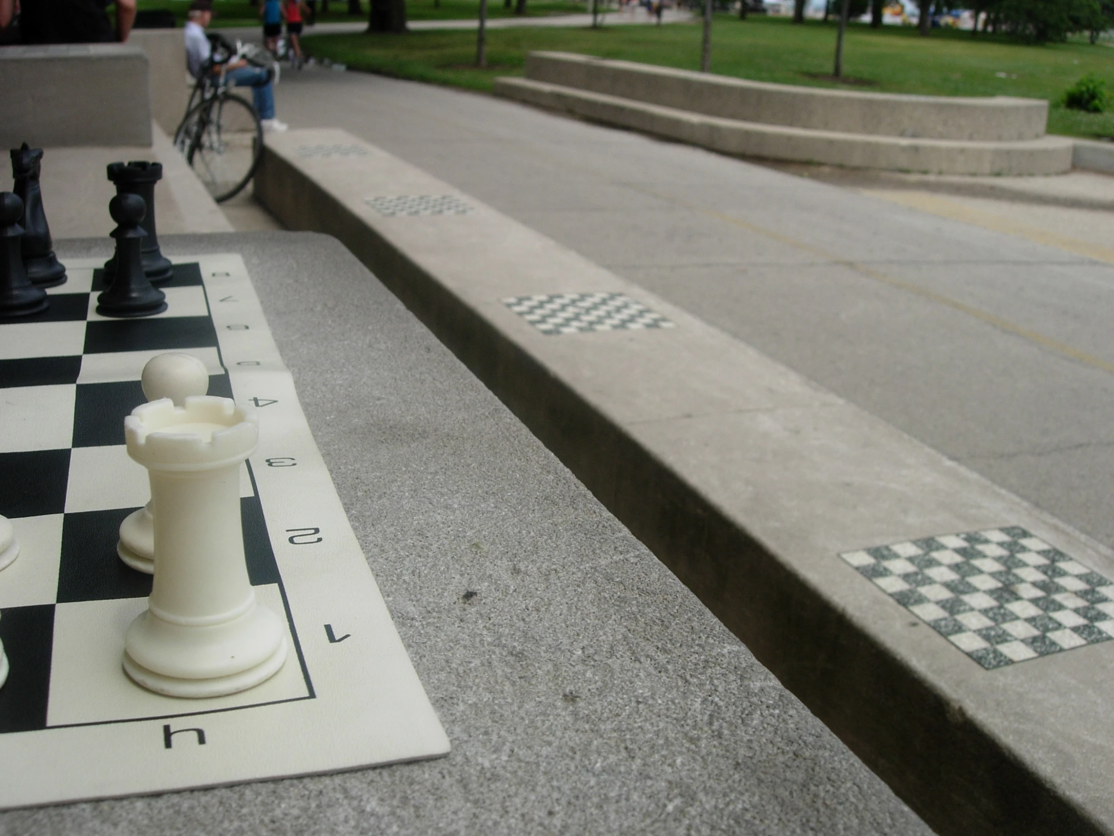 a chess board and a set of chess pieces on the side walk