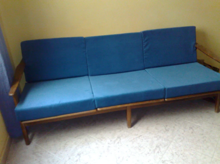 the blue sofa is sitting in the corner of the room