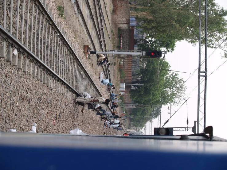 people hanging out by the railroad tracks by a traffic signal