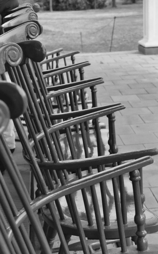 row of wooden chairs sitting on the side walk