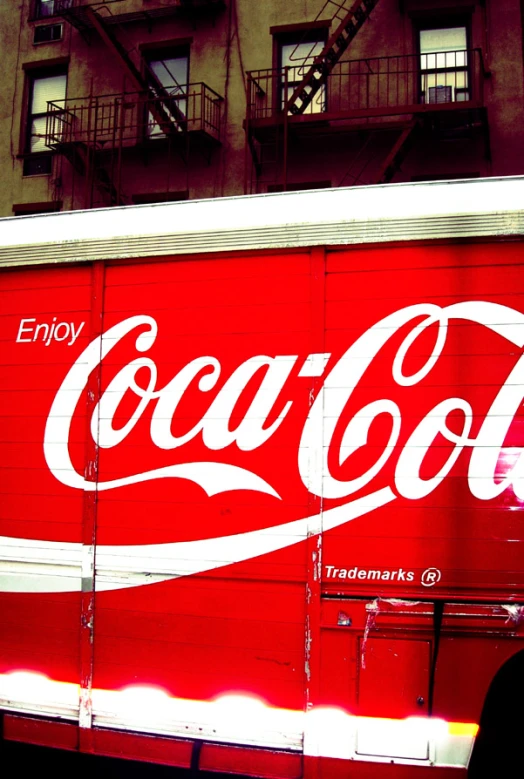 a large coca - cola box truck parked on a city street