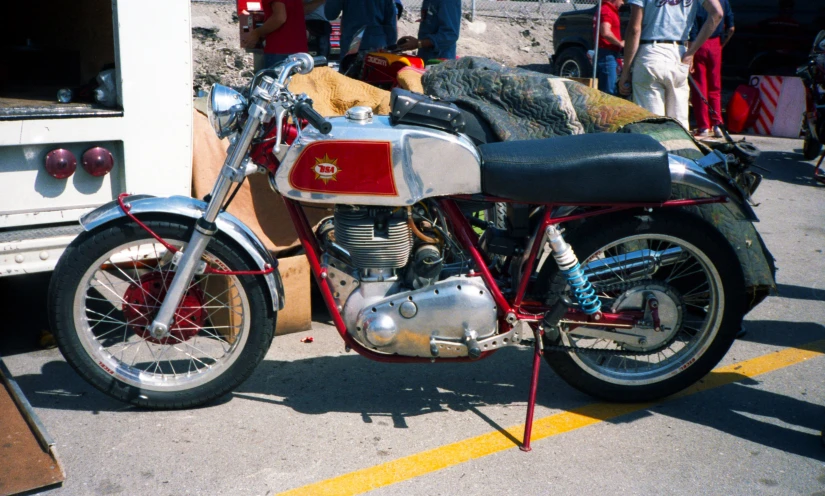 there is a old red motorcycle parked in the street