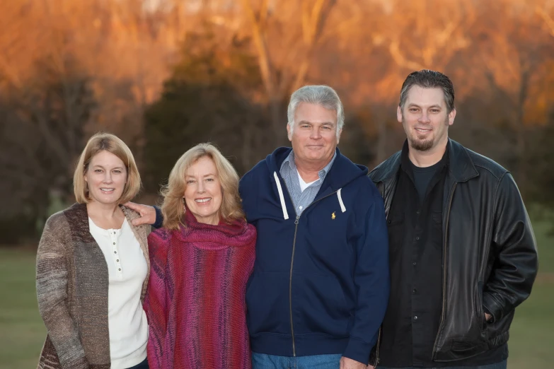 a family portrait with an orange sky in the background