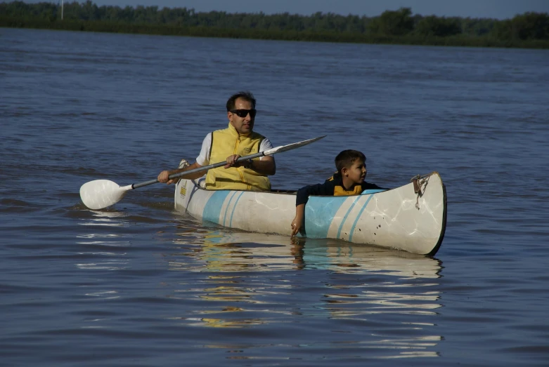 an adult and child paddling on a paddleboat