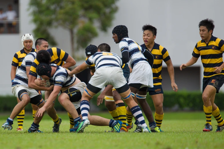 a rugby team is fighting and the man on the side looks to make a pass