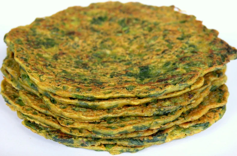 a stack of green food with green sauce
