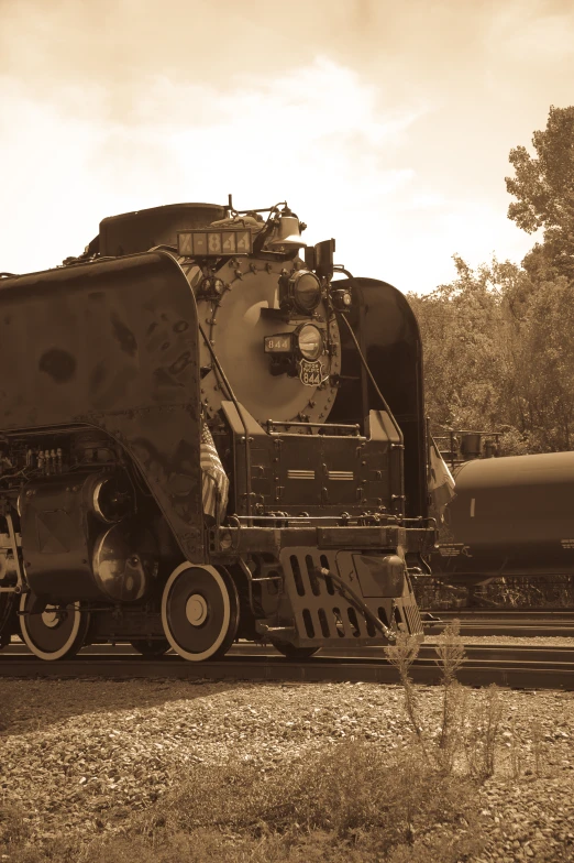 an old train has a tank attached to it