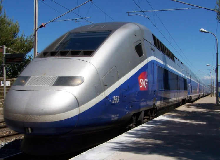 a train sits at the train stop and is stopped