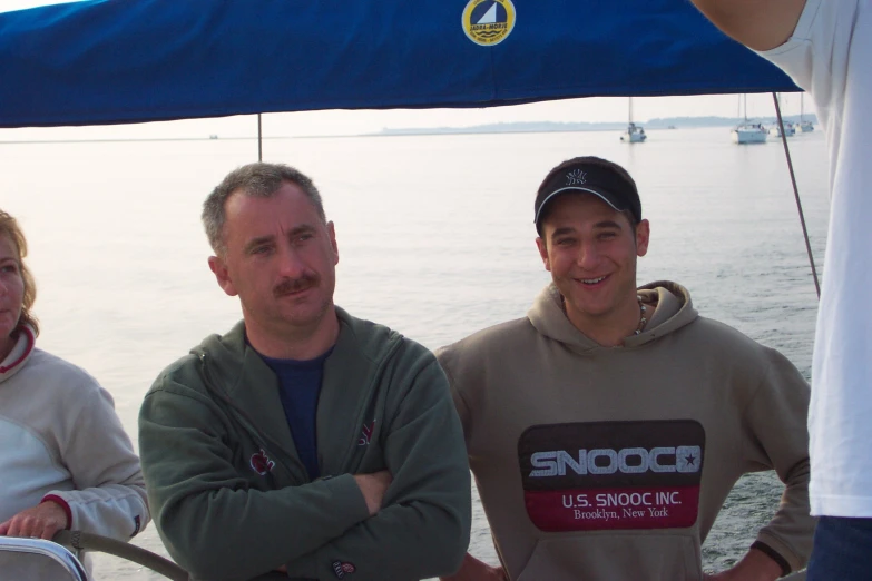 three adults and a child are standing on a boat