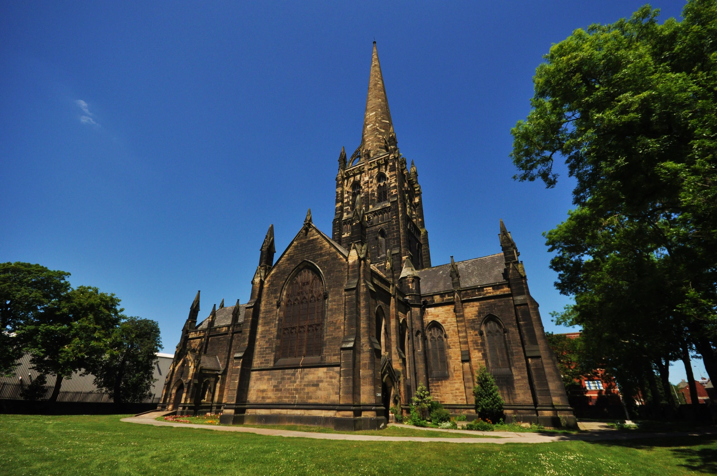 a tall, ornate cathedral towering over a lush green park