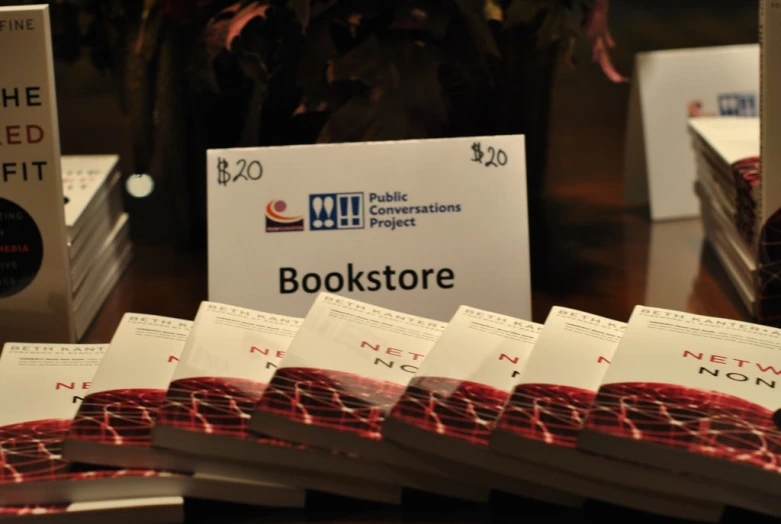 a table topped with books and piles of white papers