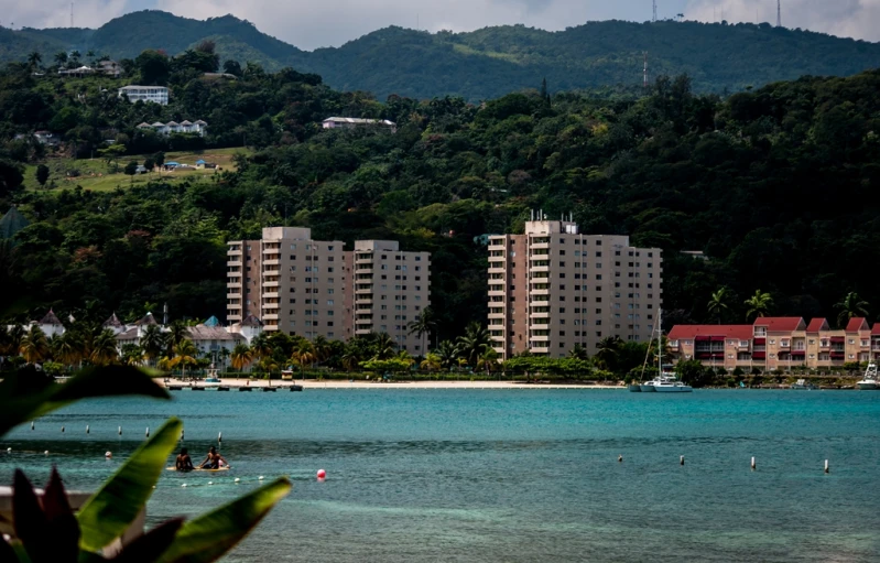 the beach houses are next to a sandy shore