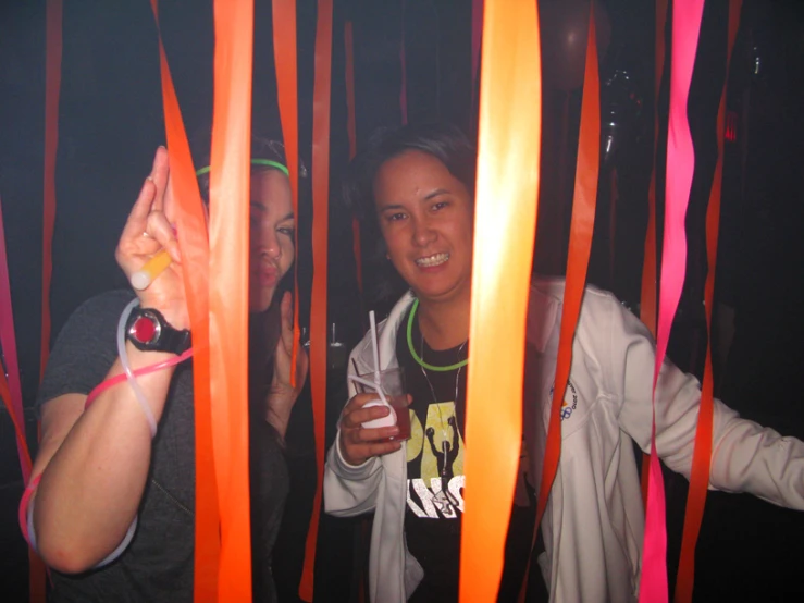 two girls are holding up orange sticks in the background