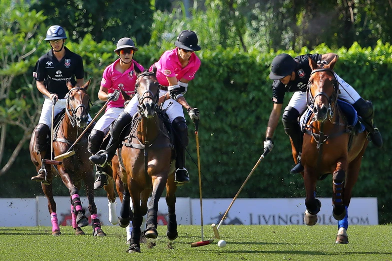 three people ride their horses during a game of polo