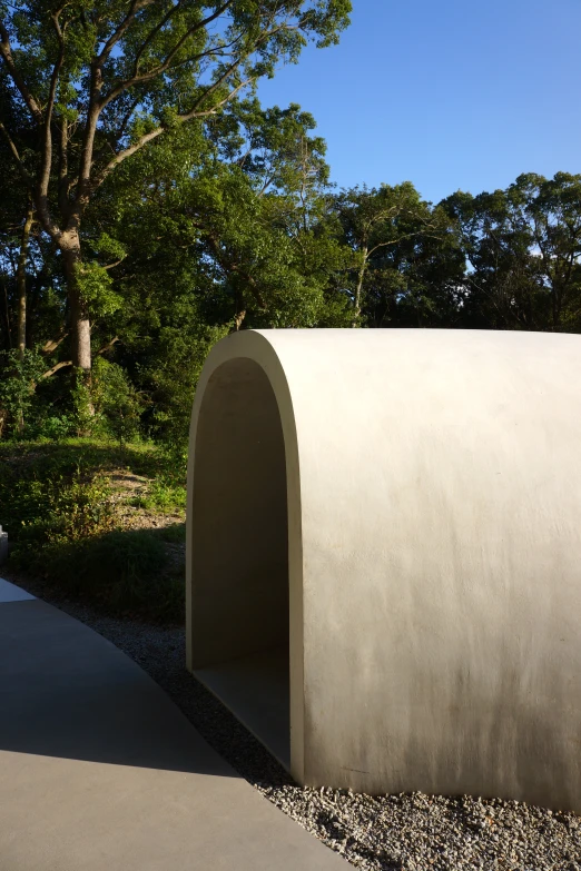 a concrete structure in the middle of a pathway with trees in the background