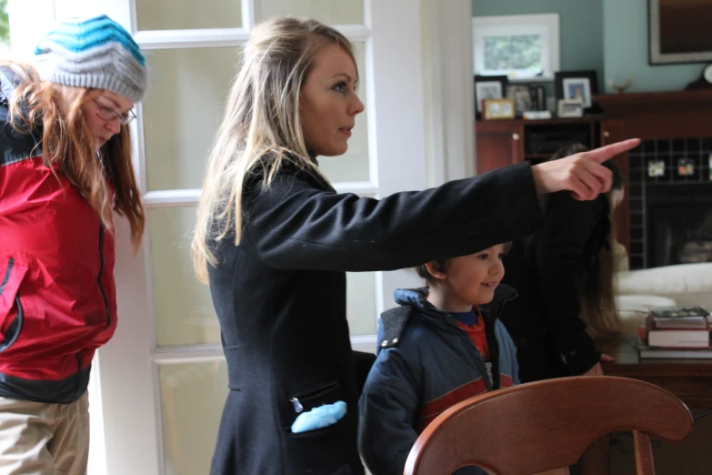 a woman pointing to another woman at the door