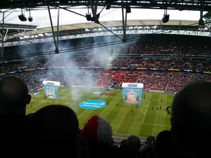 smoke is pouring out of the stands as fans stand in the center of the field