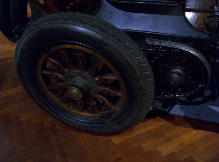 old car sitting on hardwood floor with the front wheels up