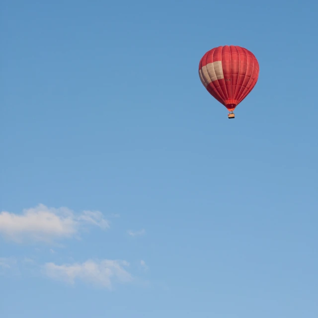 red and white  air balloon in a blue sky