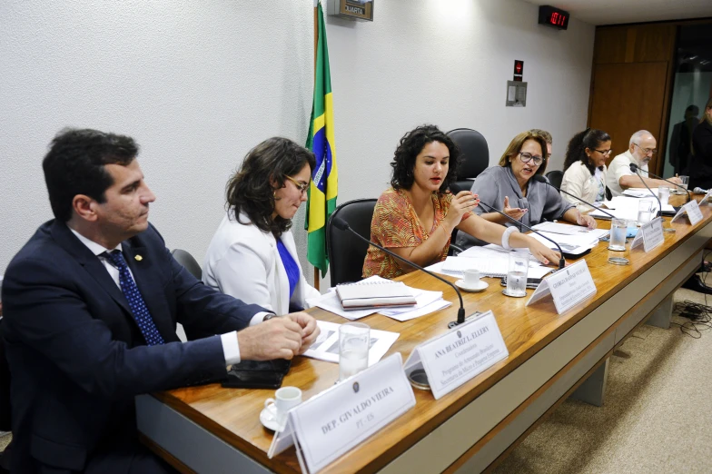 many people at a meeting one sitting while the other standing