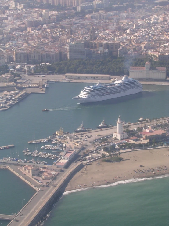 large cruise ship in harbor near city and beach