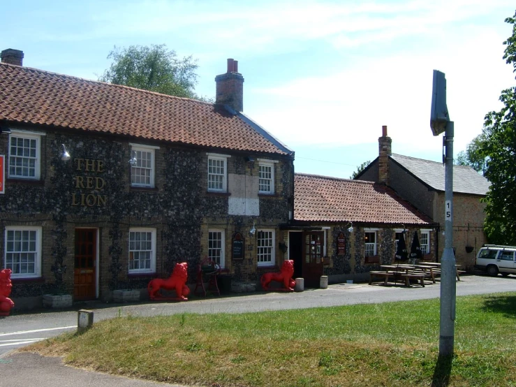 a stone building with red sculptures on it's side