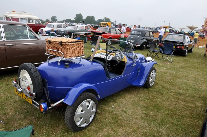 an old fashioned blue buggy at a car show