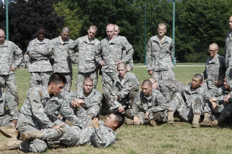 a group of military men in fatigues sitting together in a field