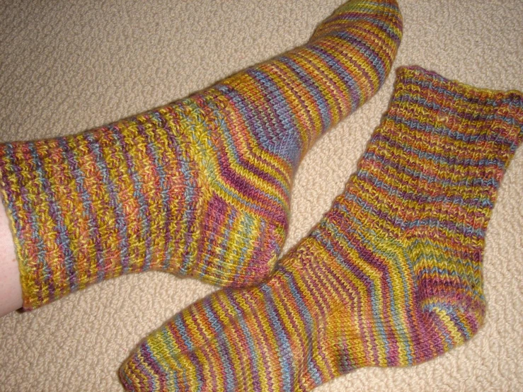 two people's feet in colorful socks on the floor