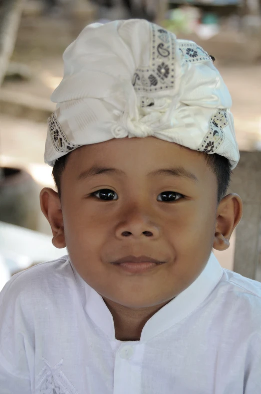 a child wearing a white shirt and hat