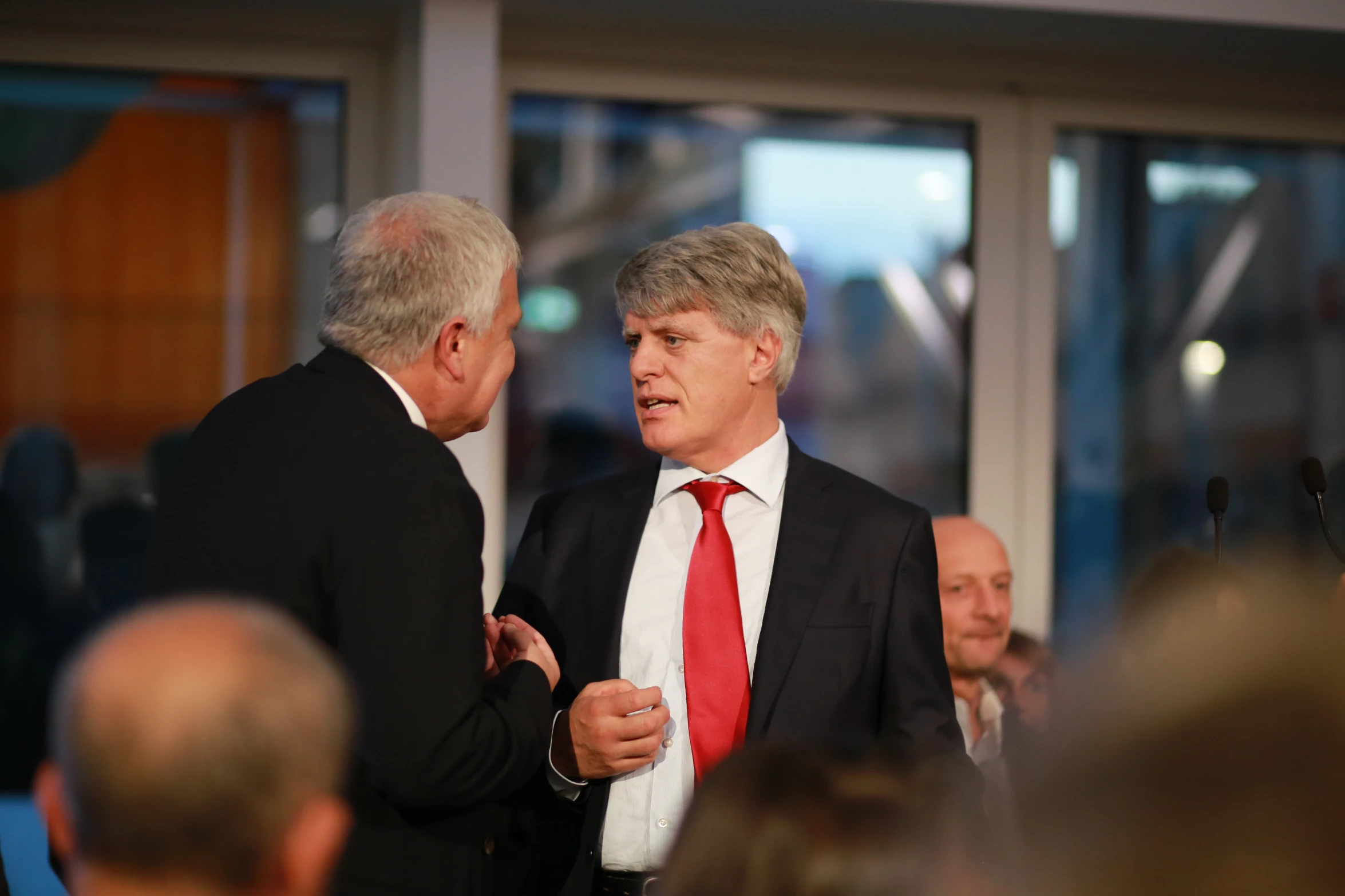 two men in business suits standing with each other