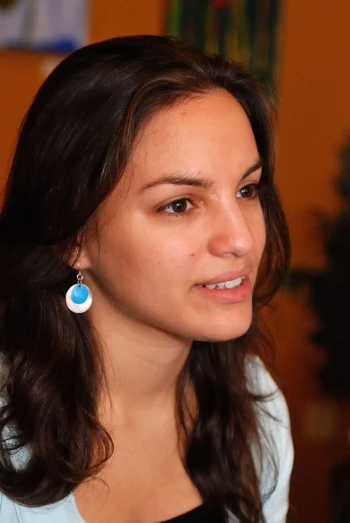 a woman in black and white shirt with a blue and white earrings