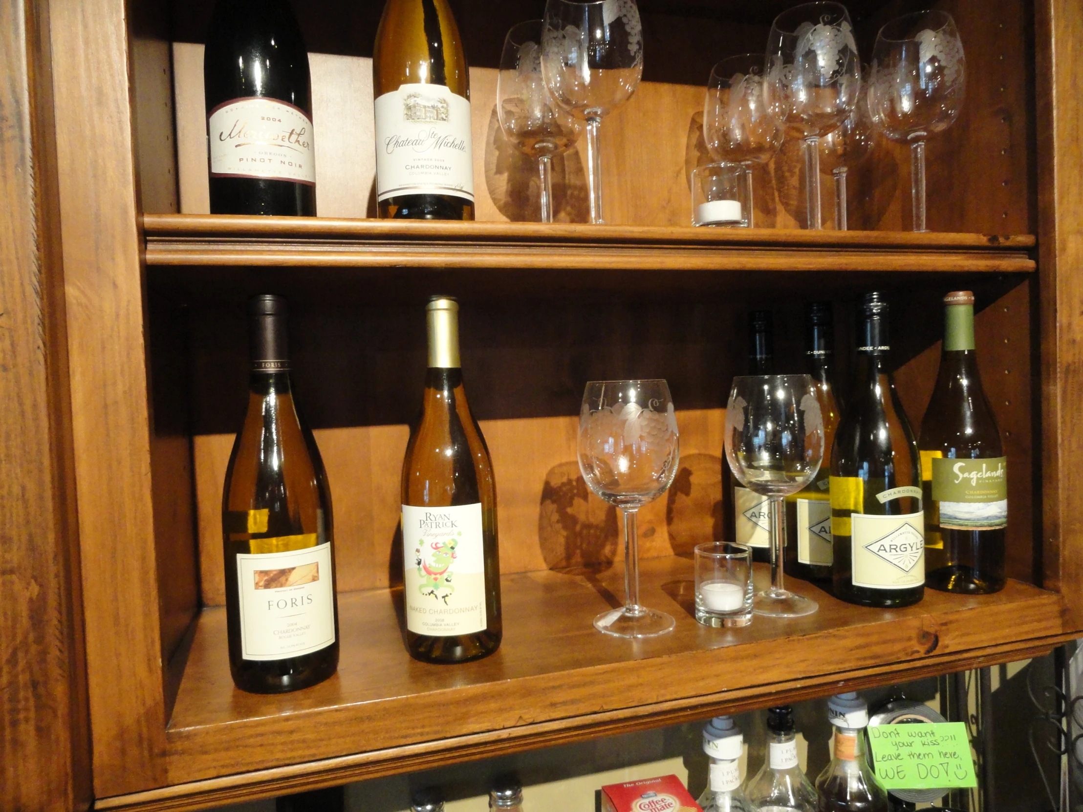 bottles of wine and glasses are on the shelf