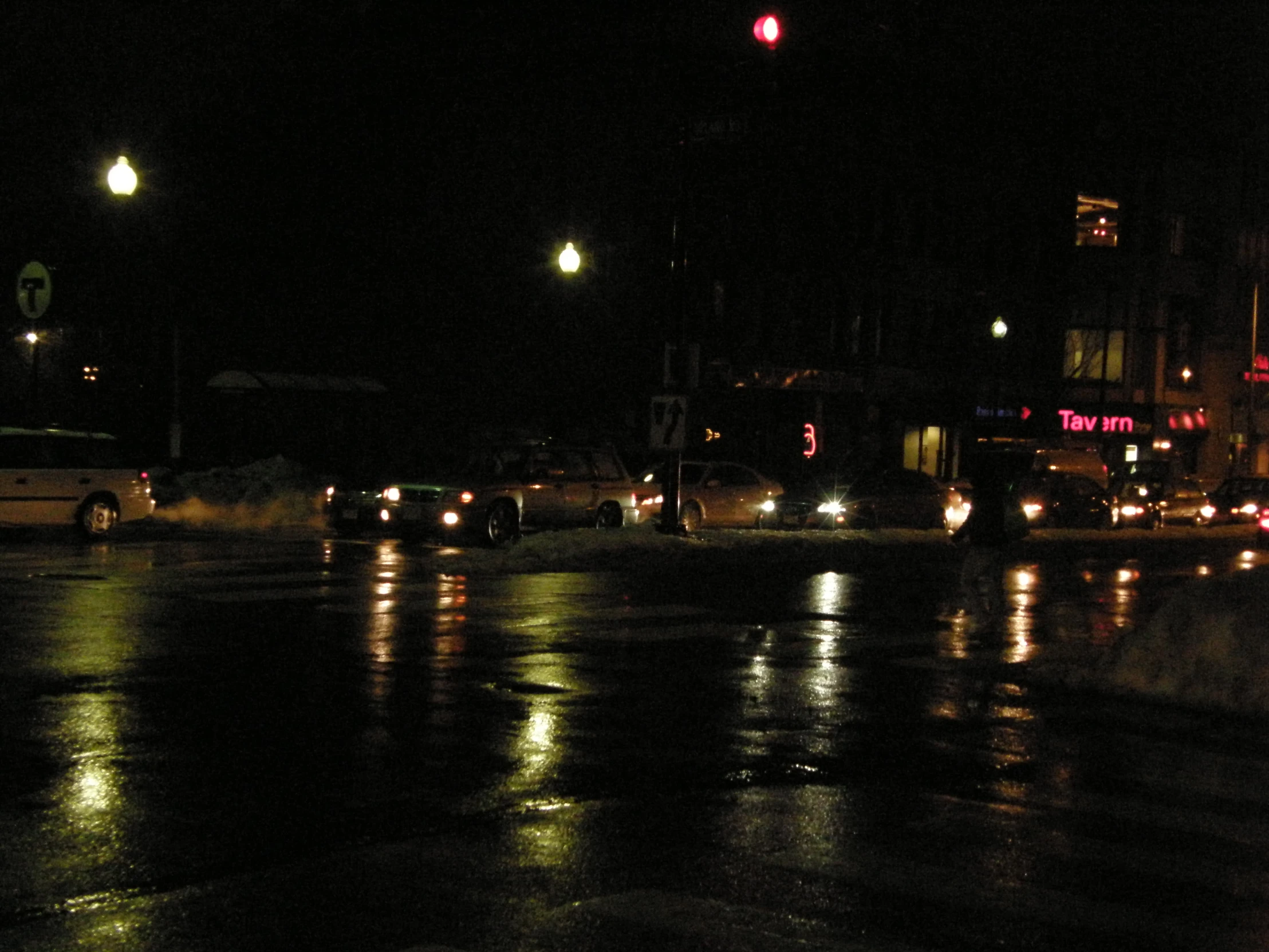 cars wait for the signal light to change at night